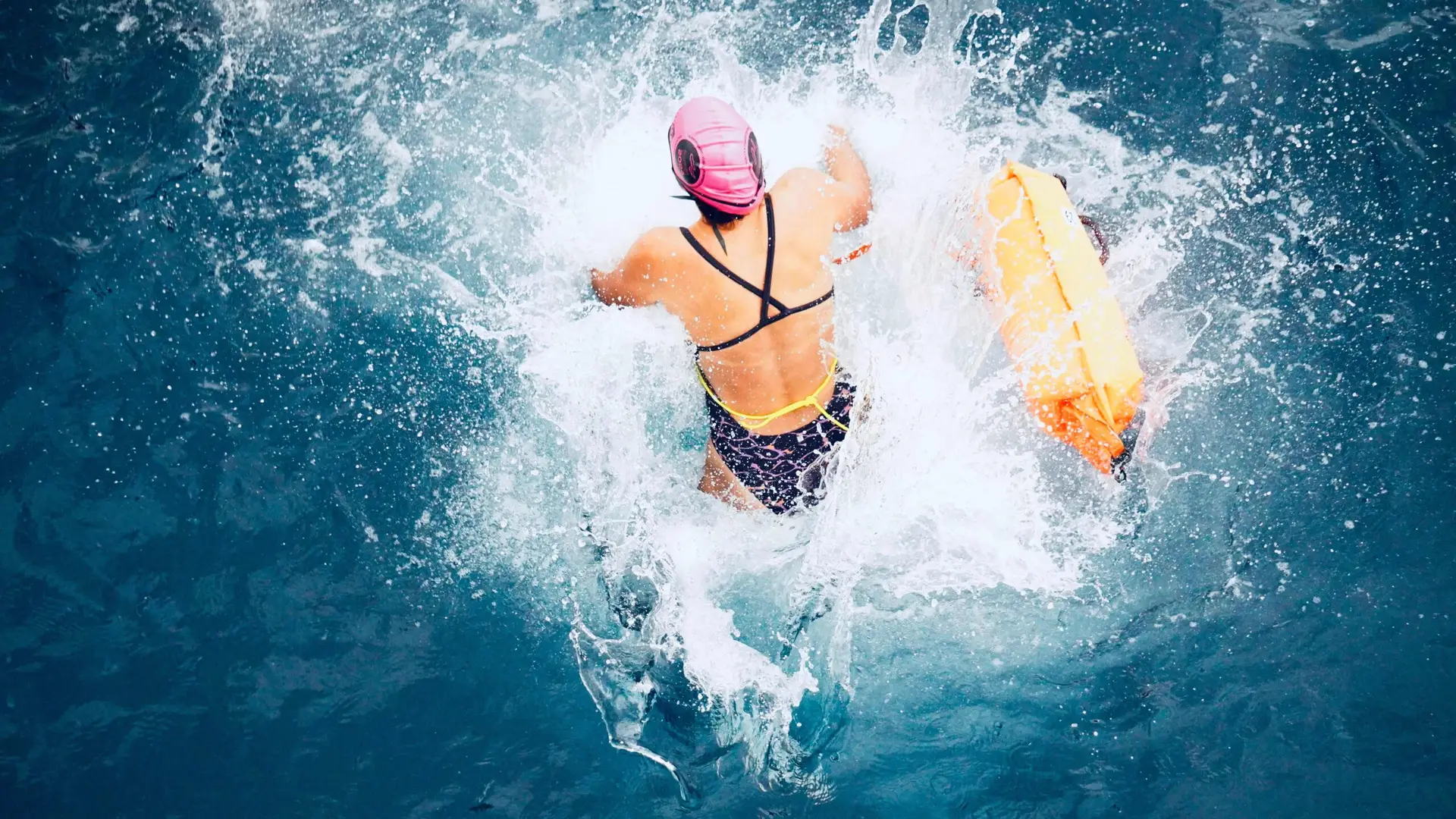 Participant jumping into the sea during the Respiralia Swimming Tour for Cystic Fibrosis 2024 in Formentera.