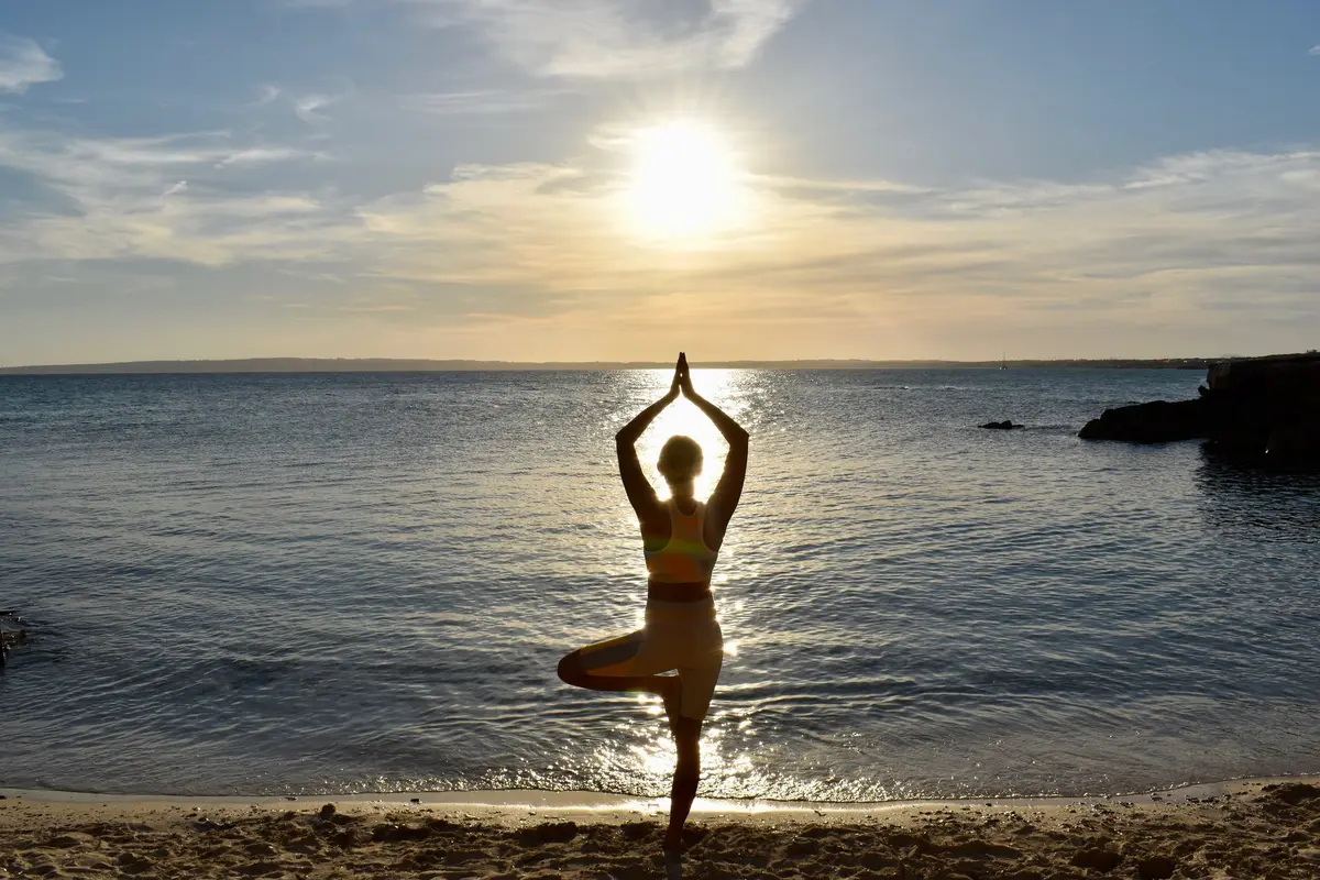 Woman doing yoga on the beach in Formentera at sunset